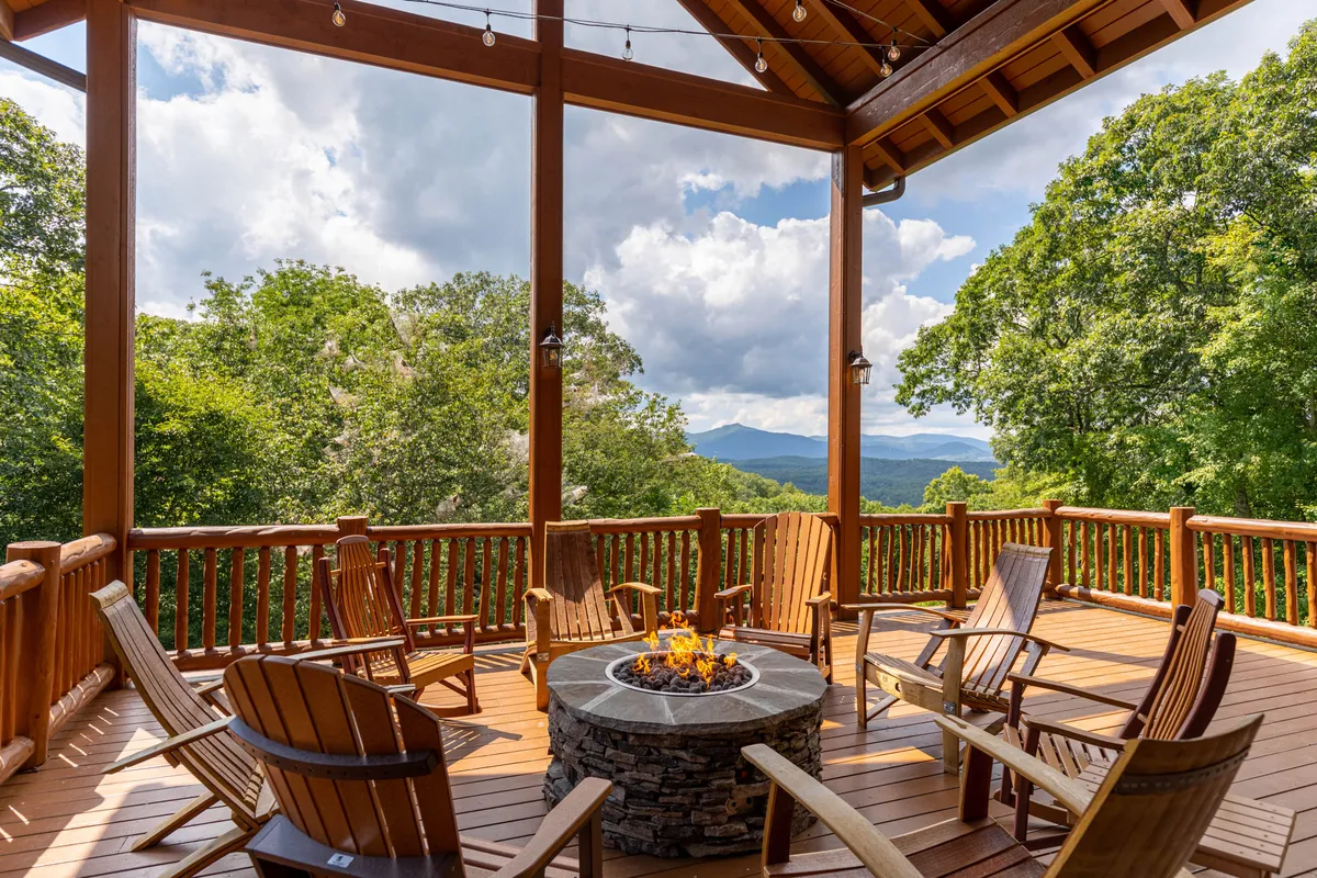 A classic stone fire pit circled by adirondack chairs, overlooking a majestic mountain view. The scene is ideal for evening gatherings, storytelling, and enjoying s’mores by the fire as the sun sets.